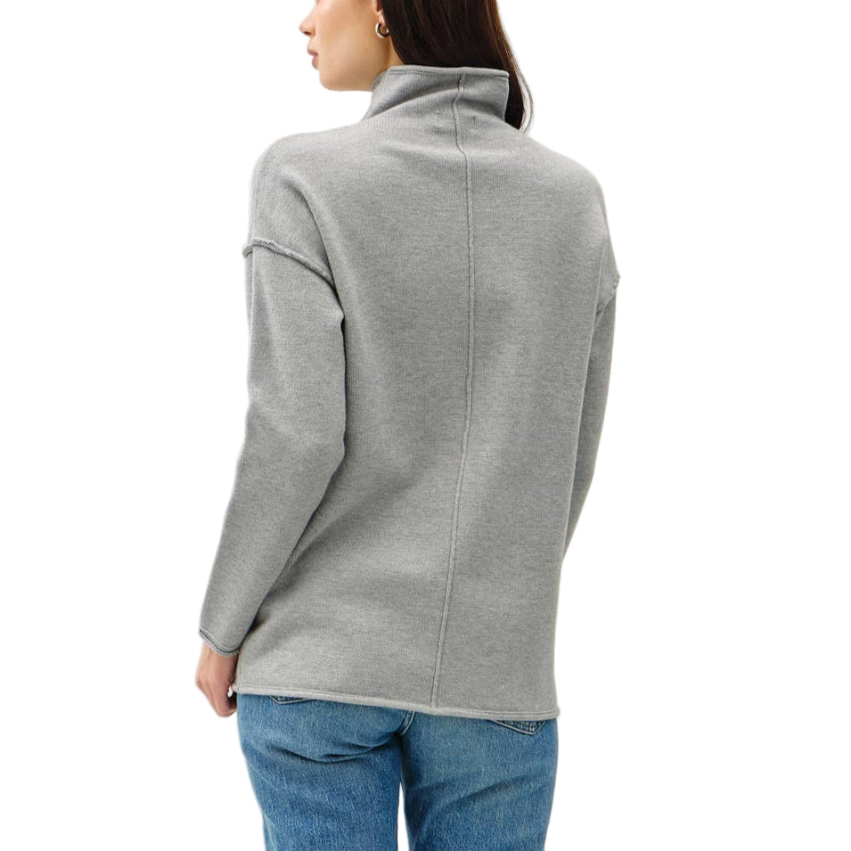 Person wearing a gray sweater and blue jeans on a white background
