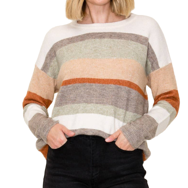 Woman wearing a colorful striped sweater against a plain background