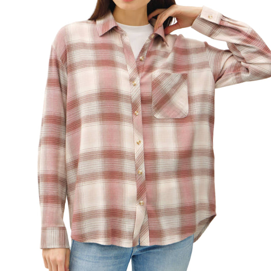 Woman wearing a plaid shirt and jeans on a plain background