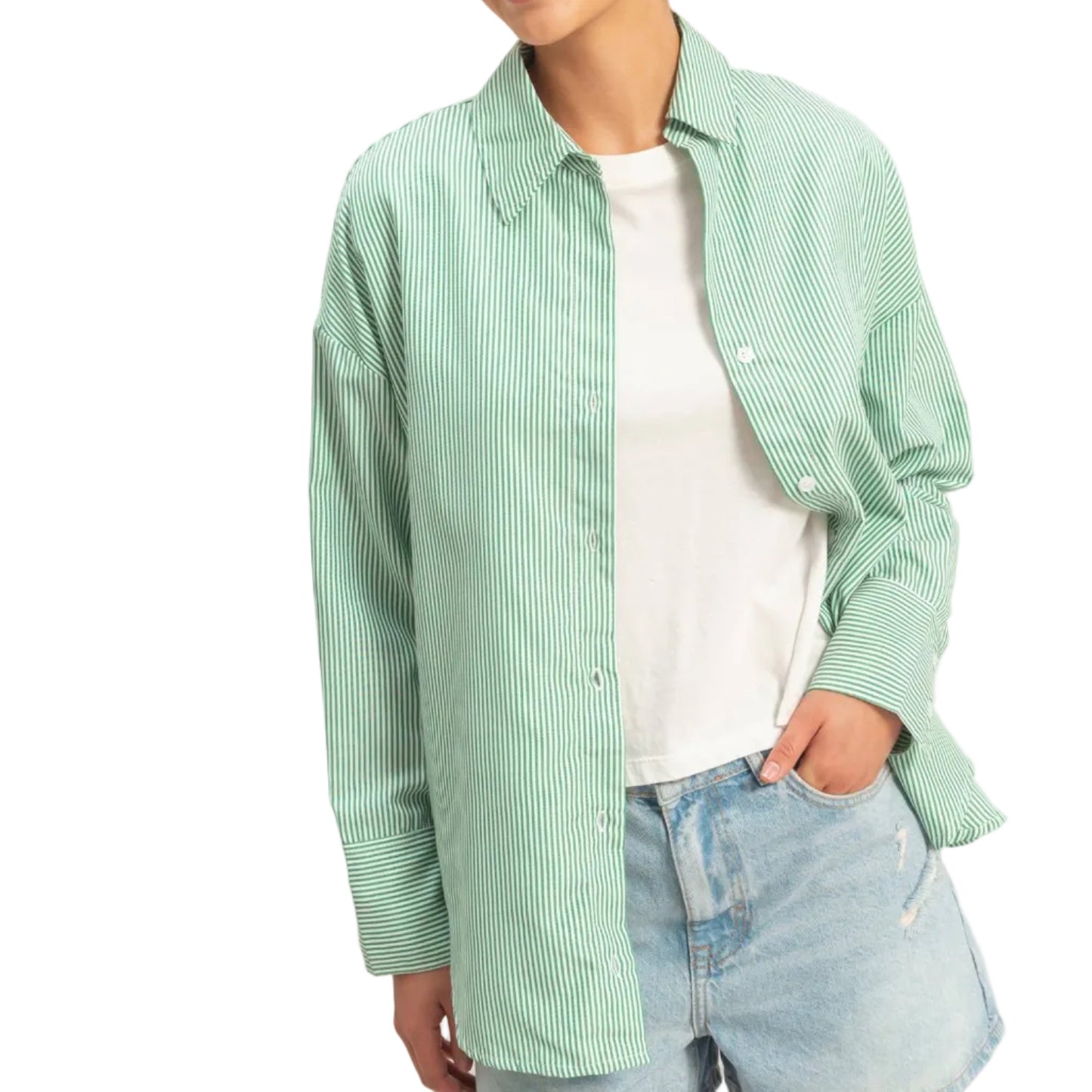 Woman wearing a green checkered shirt over a white top and denim shorts on a plain background