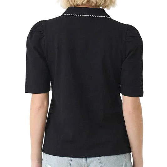 Person wearing a black polo shirt with white trim on a white background