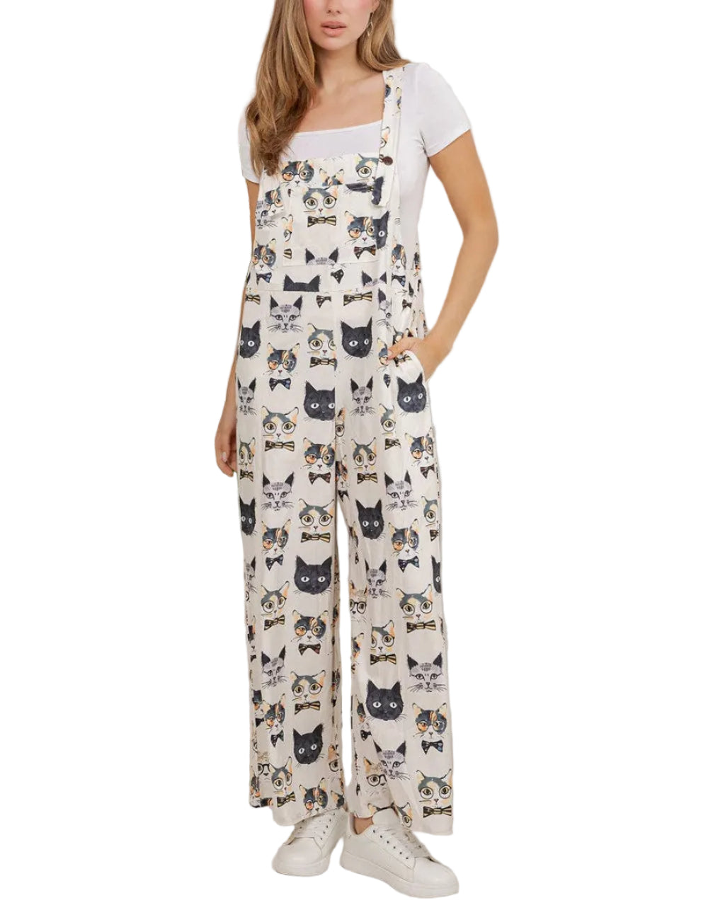 Woman wearing a cat-patterned jumpsuit in a room with plants.