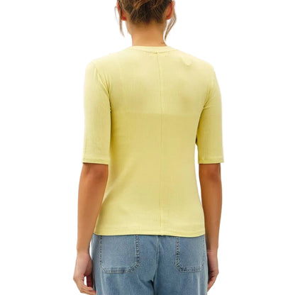 Person wearing a yellow top and light blue jeans on a white background