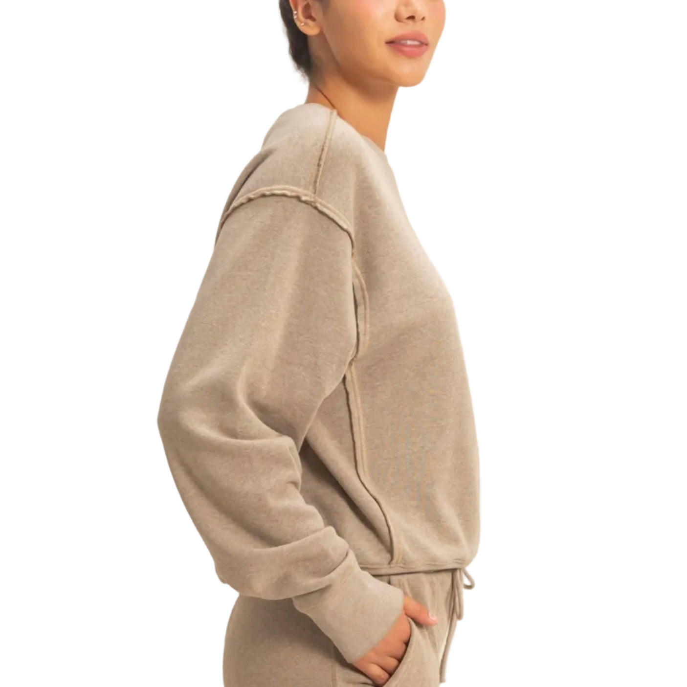 Woman wearing a beige tracksuit against a plain background