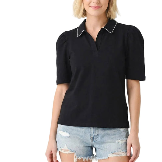 Woman wearing a black polo shirt with white trim on a white background