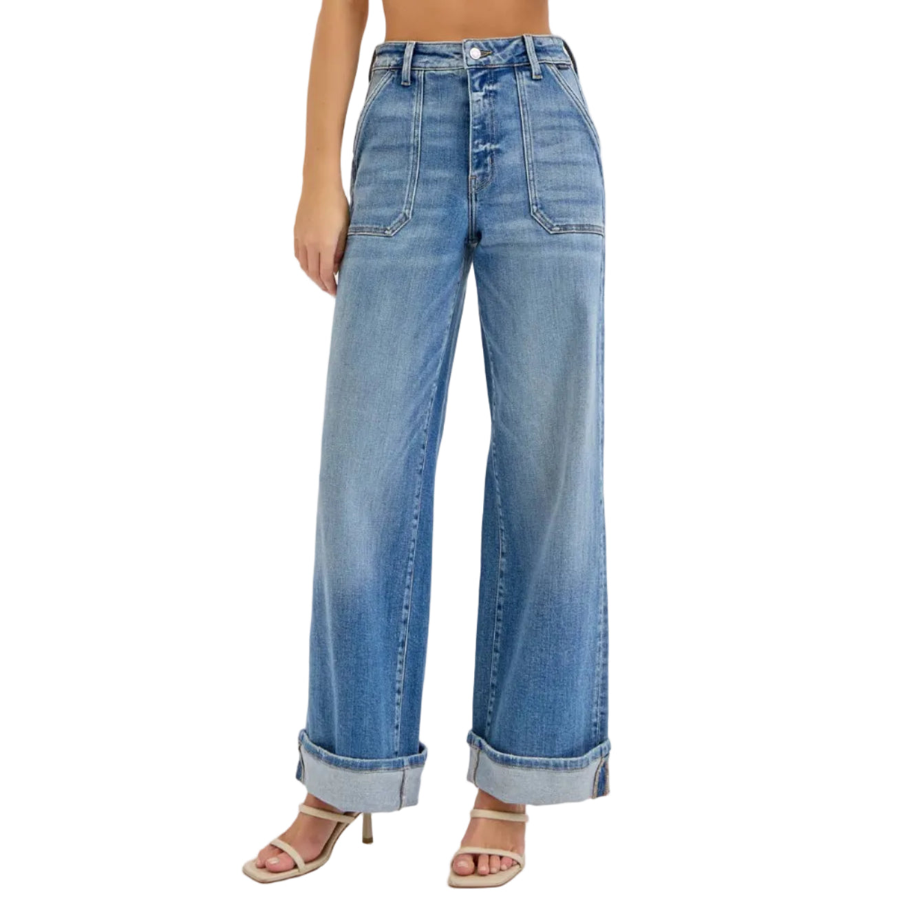 Woman wearing a beige crop top and blue jeans on a white background