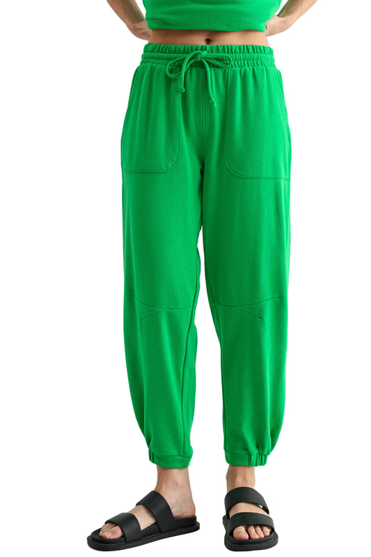 Green pants worn by a person on a white background