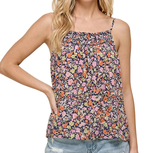 Woman wearing a floral top and denim shorts on a beige background