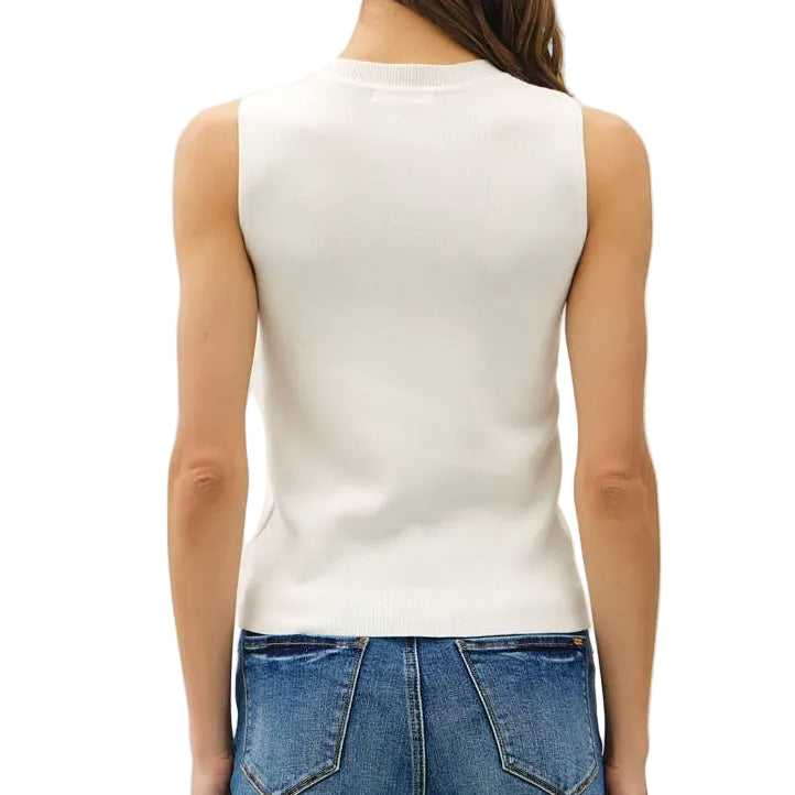 Person wearing a white sleeveless top and blue flared jeans on a plain background