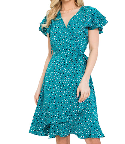 Woman wearing a teal dress with a white background