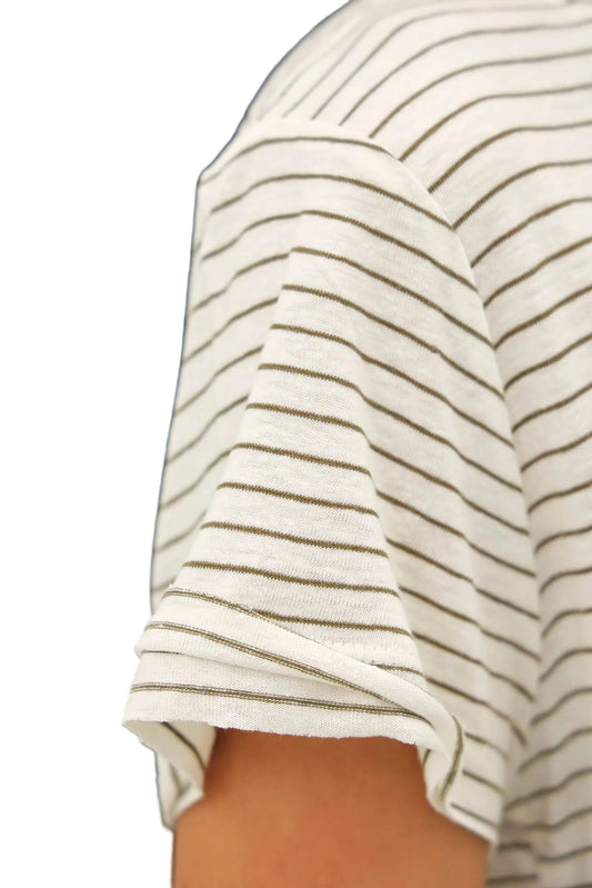 Close-up of a person wearing a white shirt with thin black stripes on a dark background