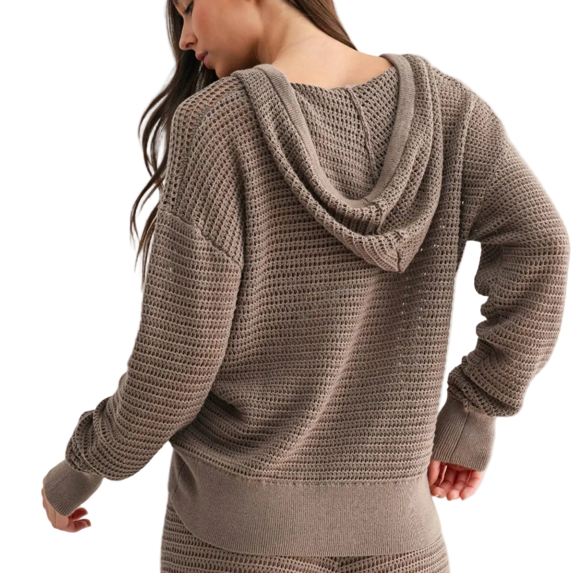 Woman wearing a brown knitted hoodie and pants on a light gray background