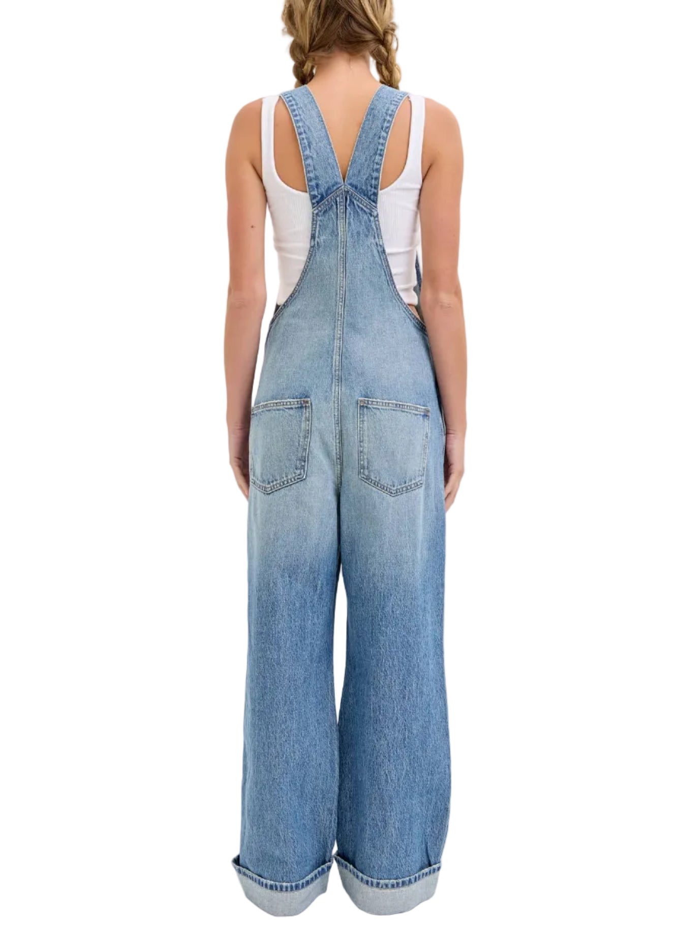 Person wearing blue denim overalls on a white background