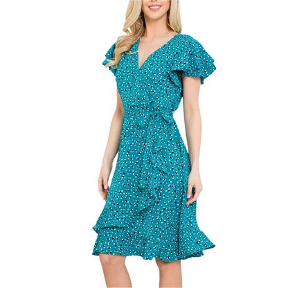 A woman wearing a teal dress with a white background 