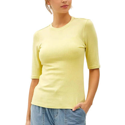 Woman wearing a yellow top and blue jeans on a white background