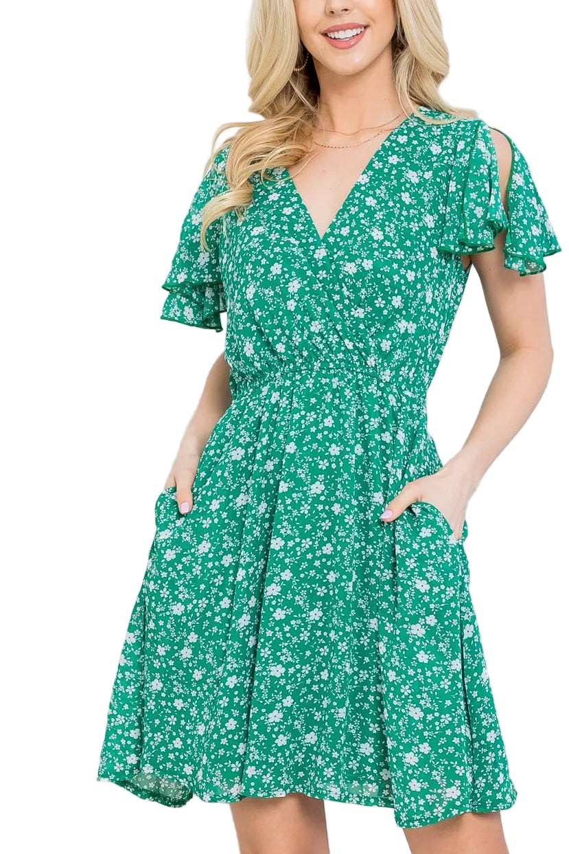 Woman wearing a green floral dress against a white background