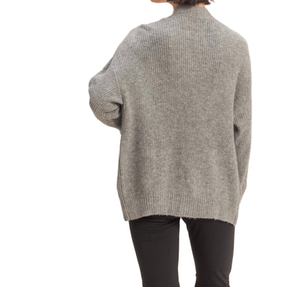 Person wearing a gray sweater on a beige background