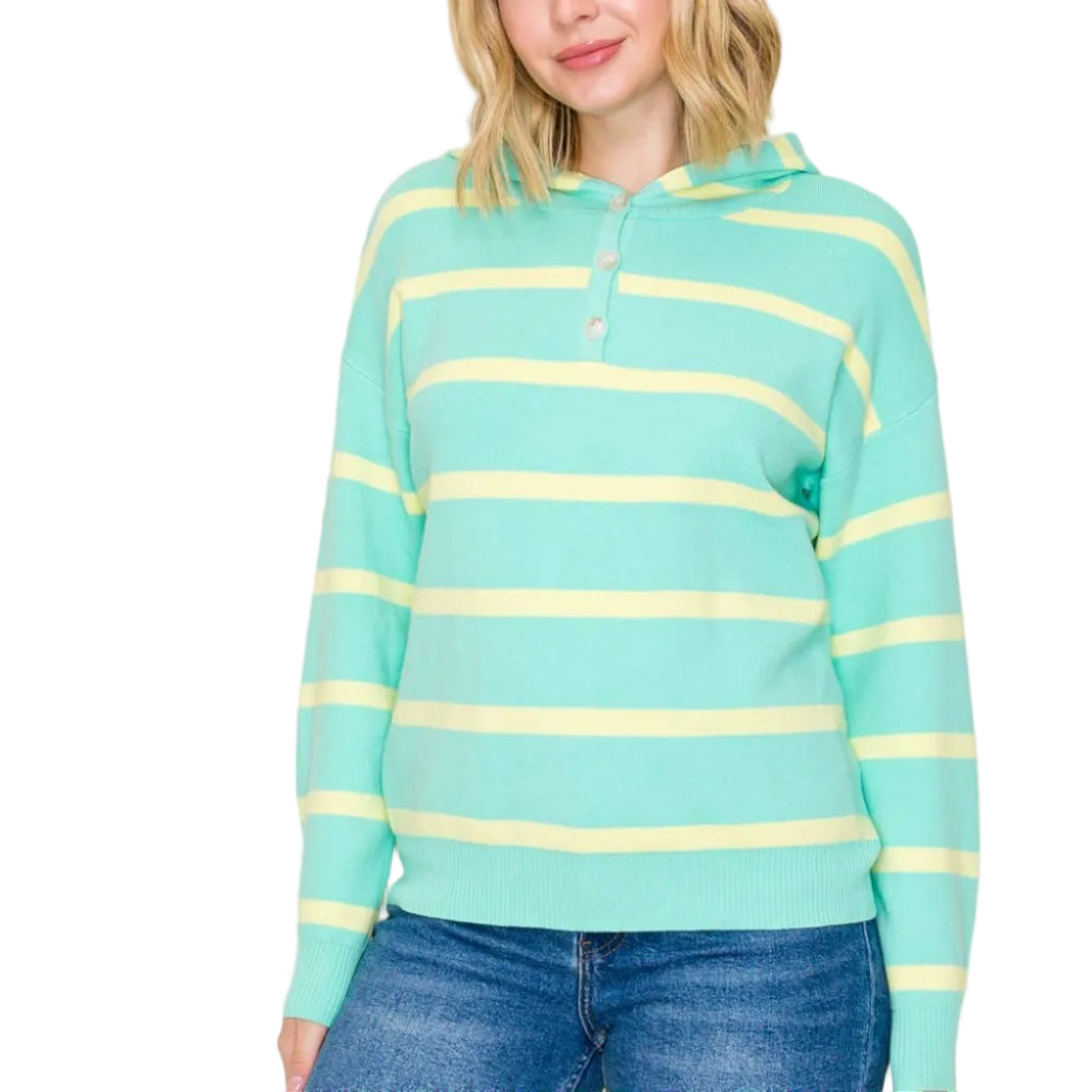 Woman wearing a light blue and yellow striped sweater against a plain background