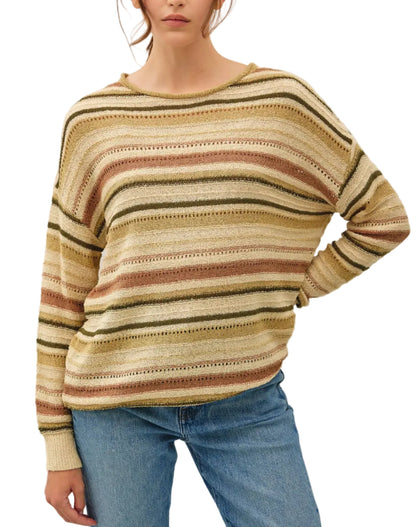 Woman wearing a striped sweater and jeans against a plain background
