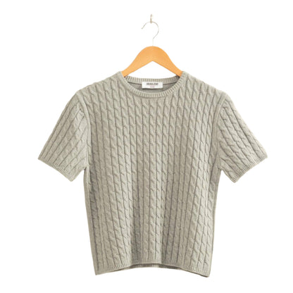 Gray textured sweater on a hanger against a beige background