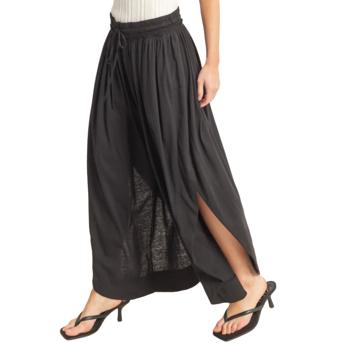 Black wide-leg pants with a white top on a plain background