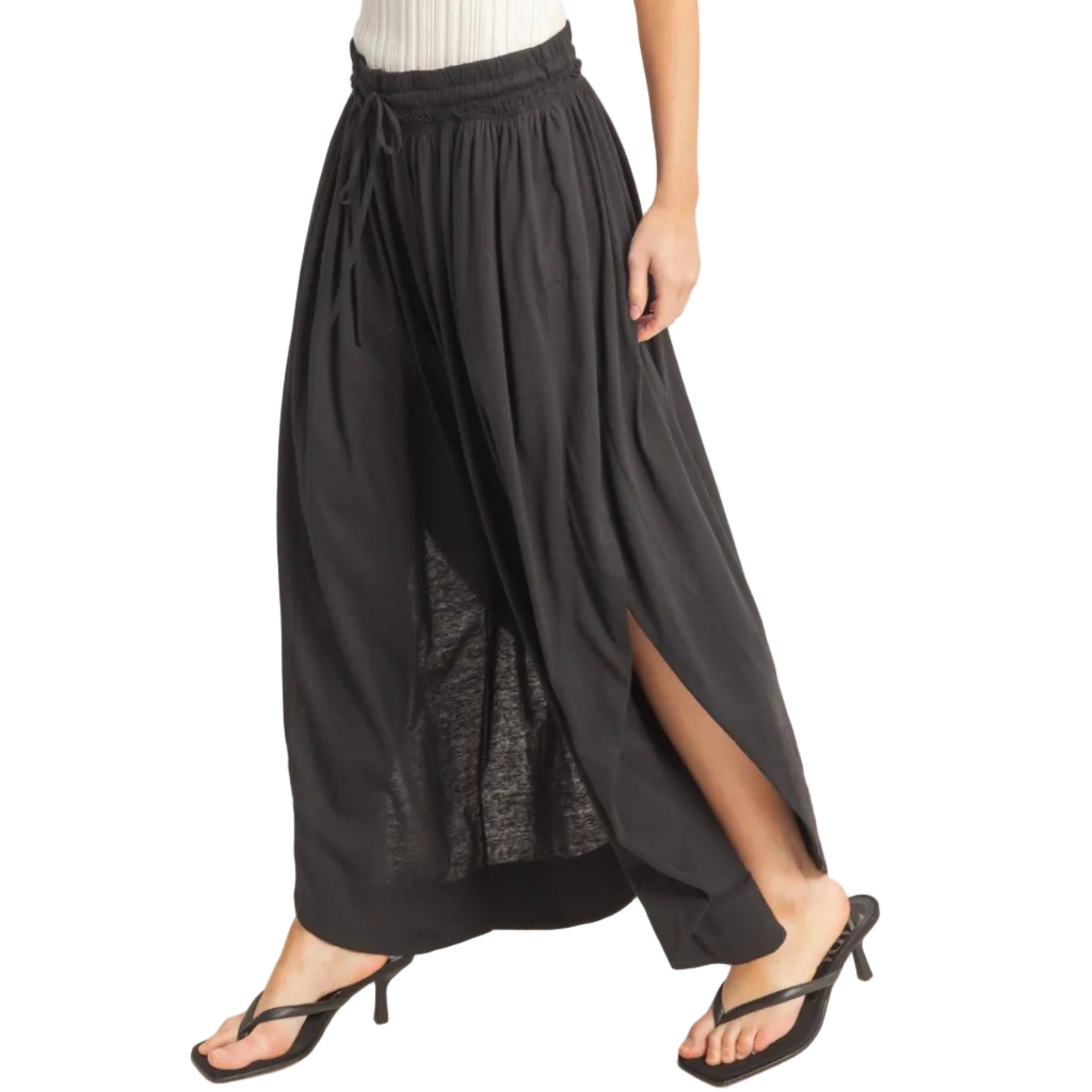Black wide-leg pants with a white top on a plain background