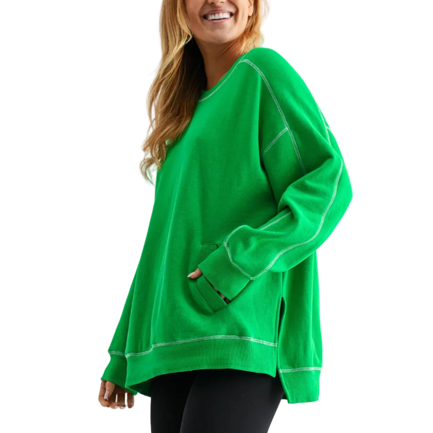 Person wearing a bright green oversized sweater with black leggings and brown boots on a white background