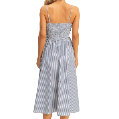 Woman wearing a blue and white striped dress on a plain background