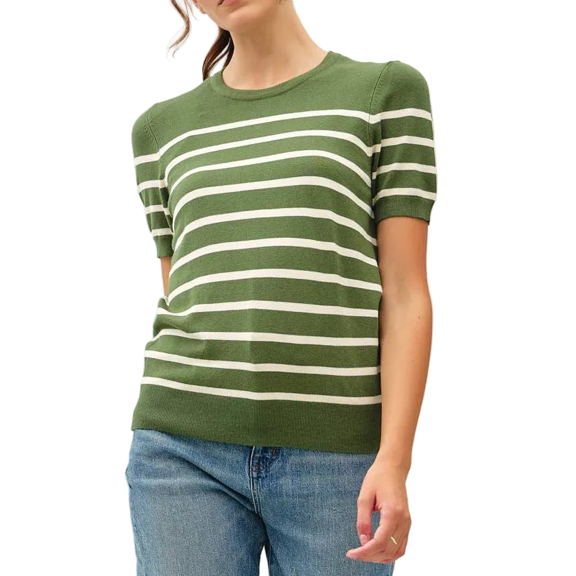 Woman wearing a green and white striped sweater and blue jeans on a white background