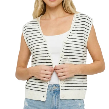 Woman wearing a striped vest over a white shirt and denim shorts on a plain background