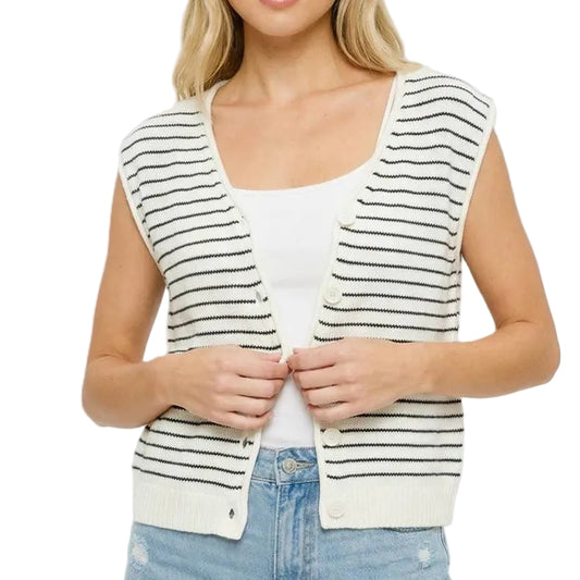 Woman wearing a striped vest over a white shirt and denim shorts on a plain background