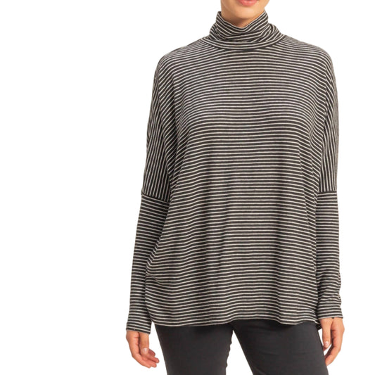 Person wearing a black and gray striped turtleneck sweater on a beige background