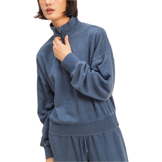 Woman wearing a blue tracksuit against a beige background