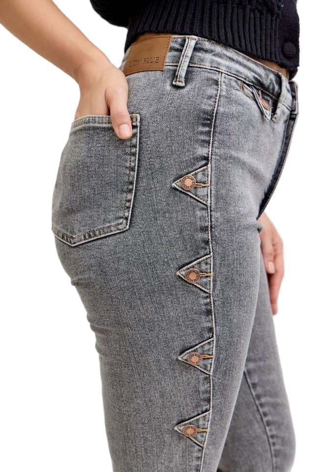 Gray jeans with decorative buttons on a neutral background