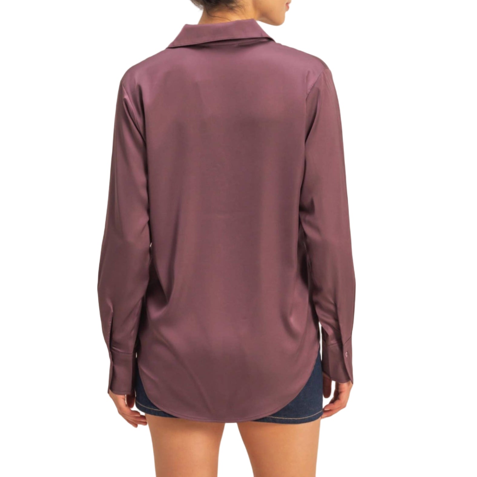 Woman wearing a long-sleeve maroon shirt against a beige background