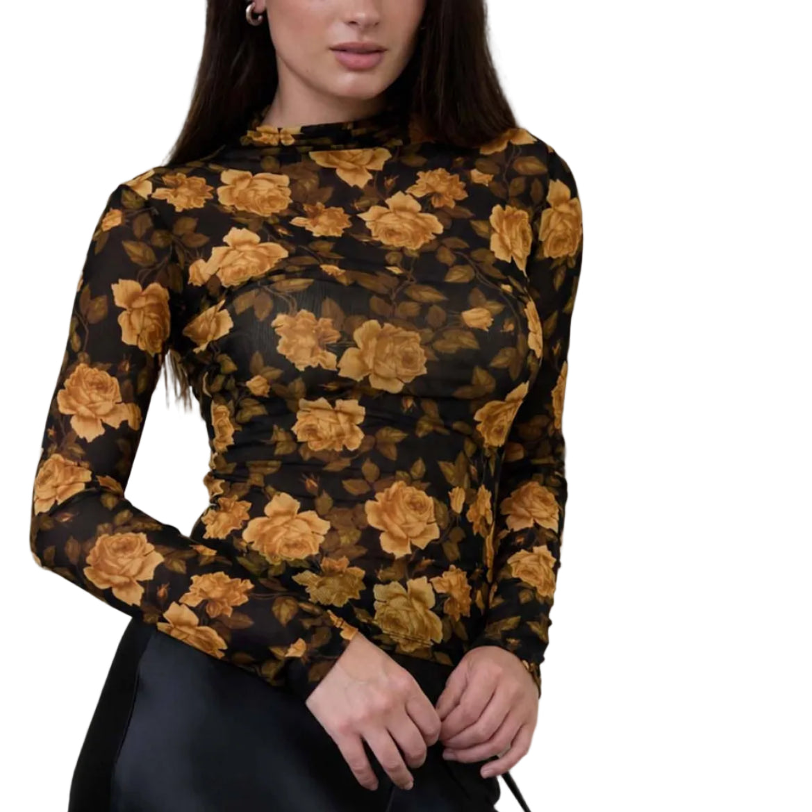 Woman wearing a black floral top and black skirt holding a black handbag against a textured beige wall.