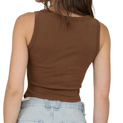 Woman wearing a brown tank top and denim shorts on a plain background