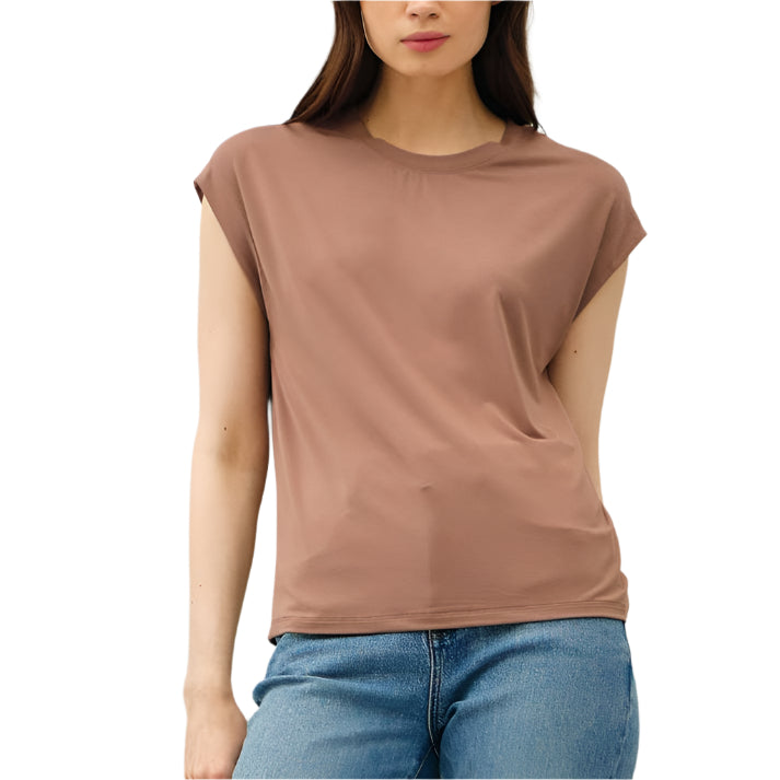 Woman wearing a brown top and blue jeans against a white background