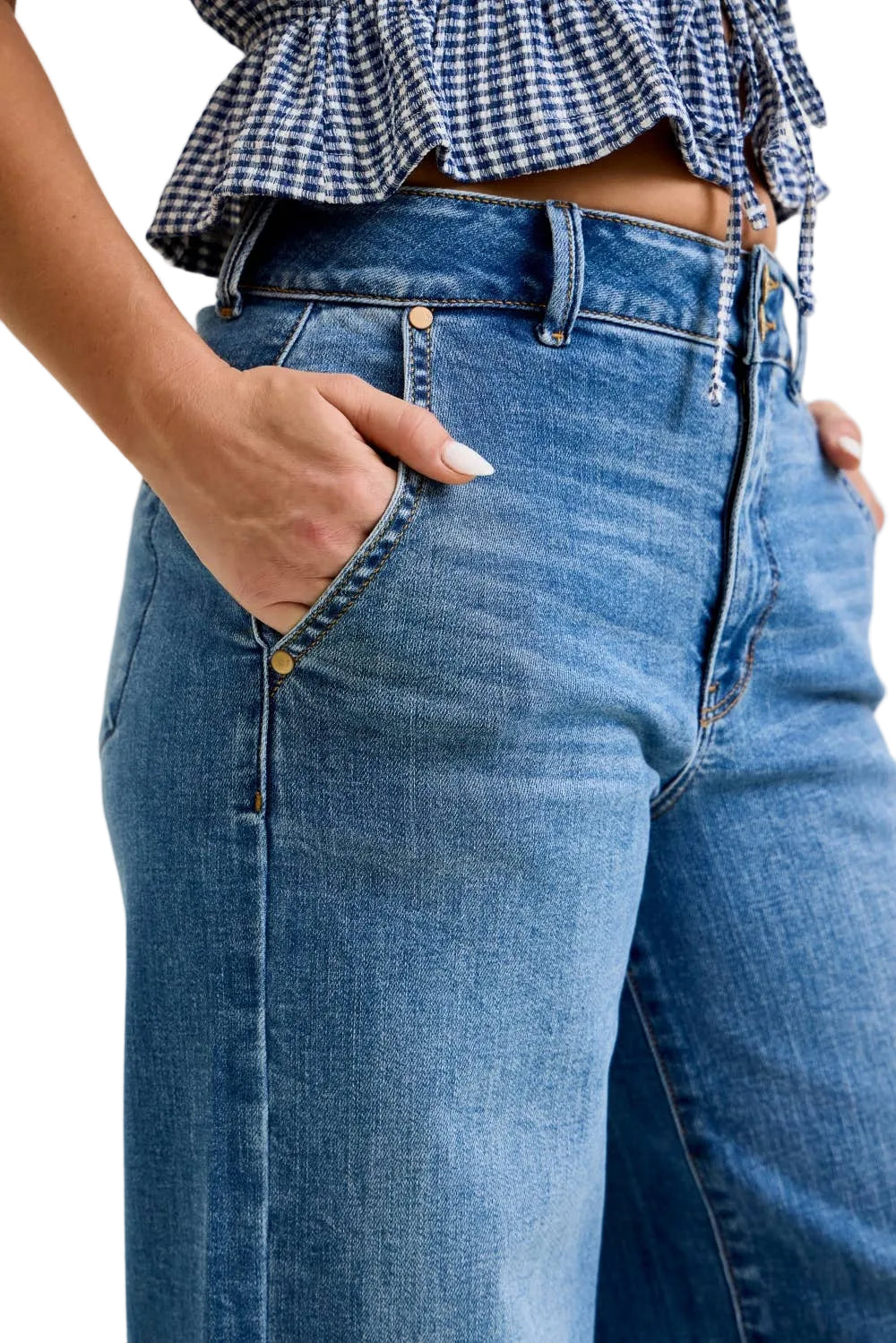Person wearing blue jeans and a checkered top on a plain background