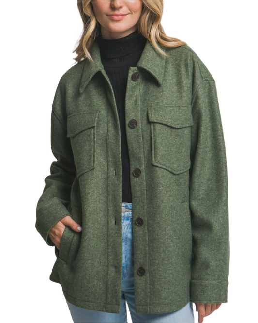 Woman wearing a green coat against a plain background