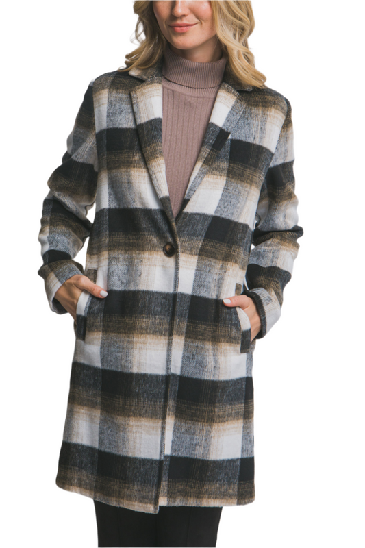 Woman wearing a plaid coat on a plain background