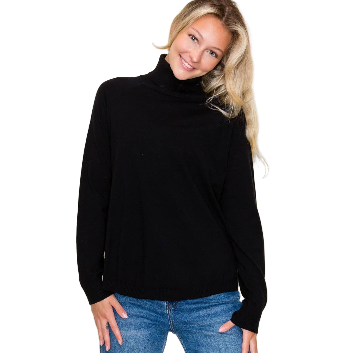 Woman wearing a black turtleneck sweater and blue jeans against a white background