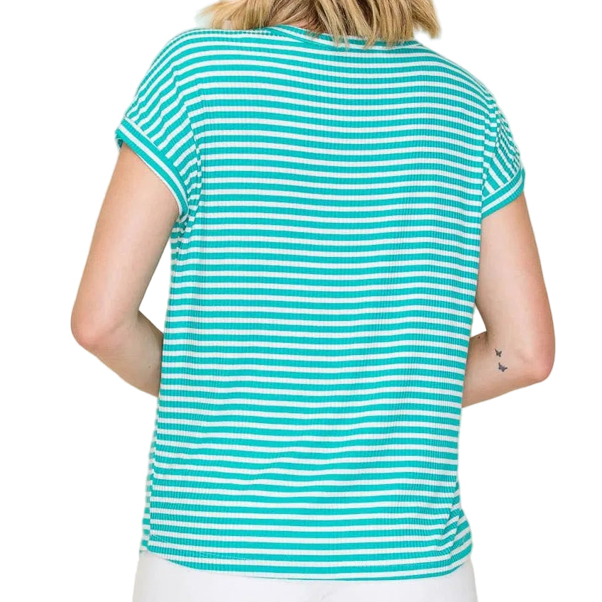 Woman wearing a turquoise and white striped shirt with white shorts on a beige background