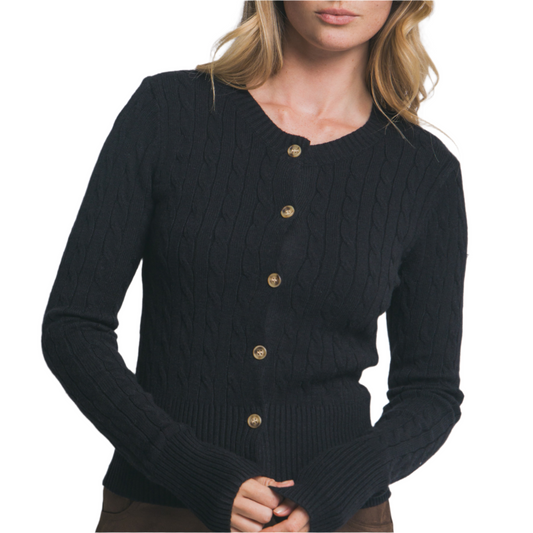 Woman wearing a black cardigan with gold buttons against a plain background