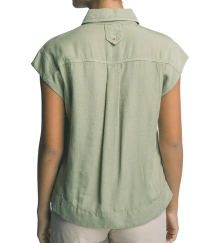 Person wearing a green sleeveless shirt against a plain background