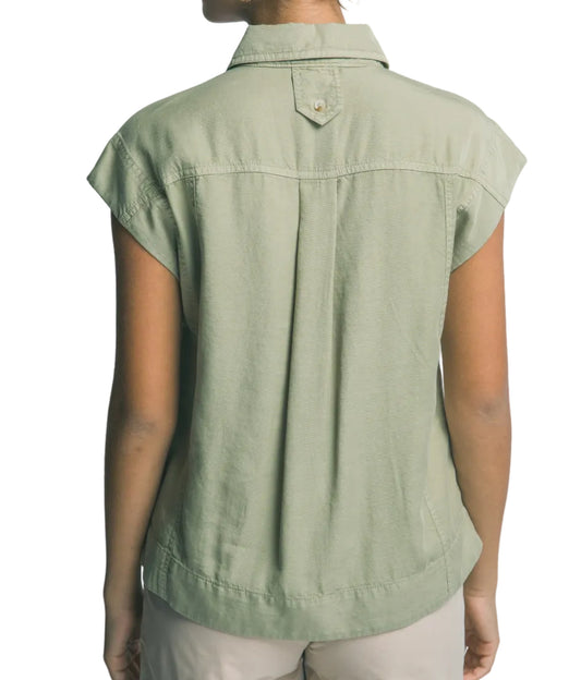 Person wearing a green sleeveless shirt against a plain background