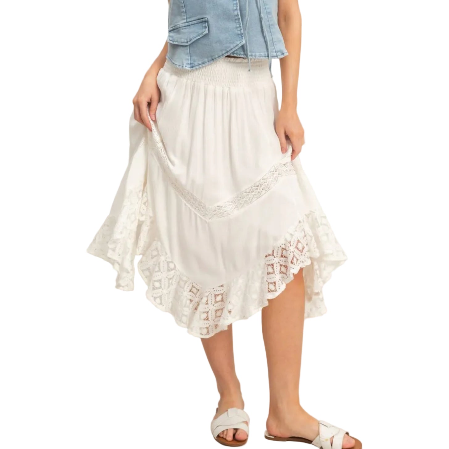 Woman wearing a denim top and white lace skirt on a plain background