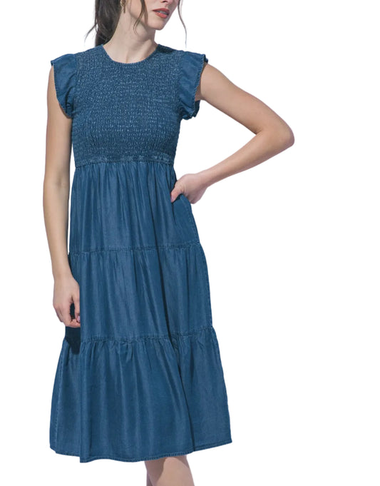 Woman wearing a blue dress against a light gray background