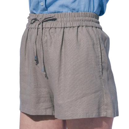 Person wearing beige shorts and a blue shirt against a light gray background