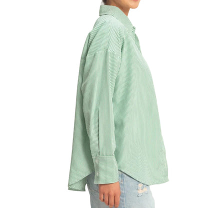 Person wearing a light green checkered shirt and denim shorts on a plain background